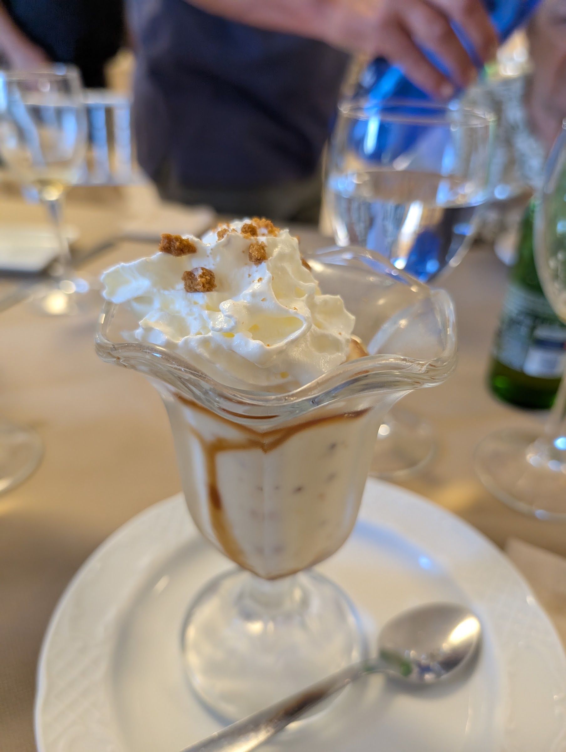 Postre casero servido en copa con nata montada y galleta